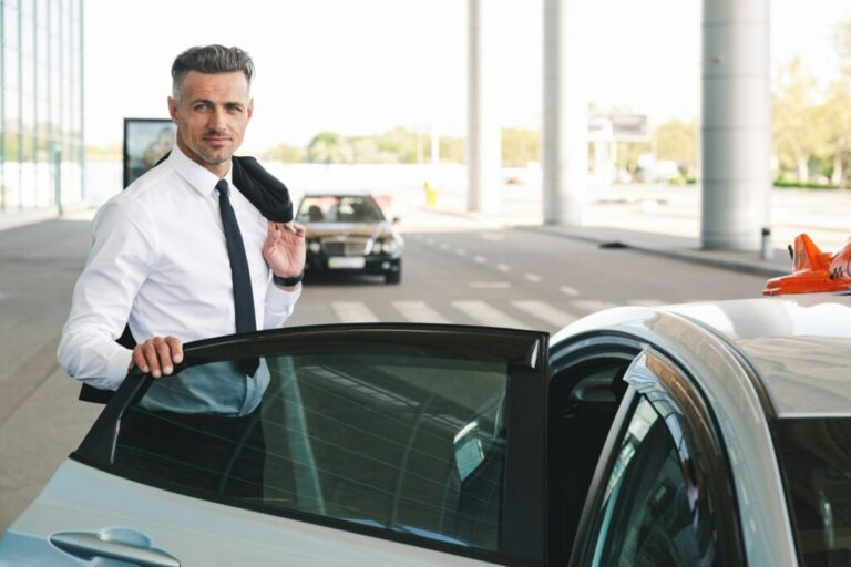 smiling mature businessman getting in taxi outside 1024x682 1 768x512